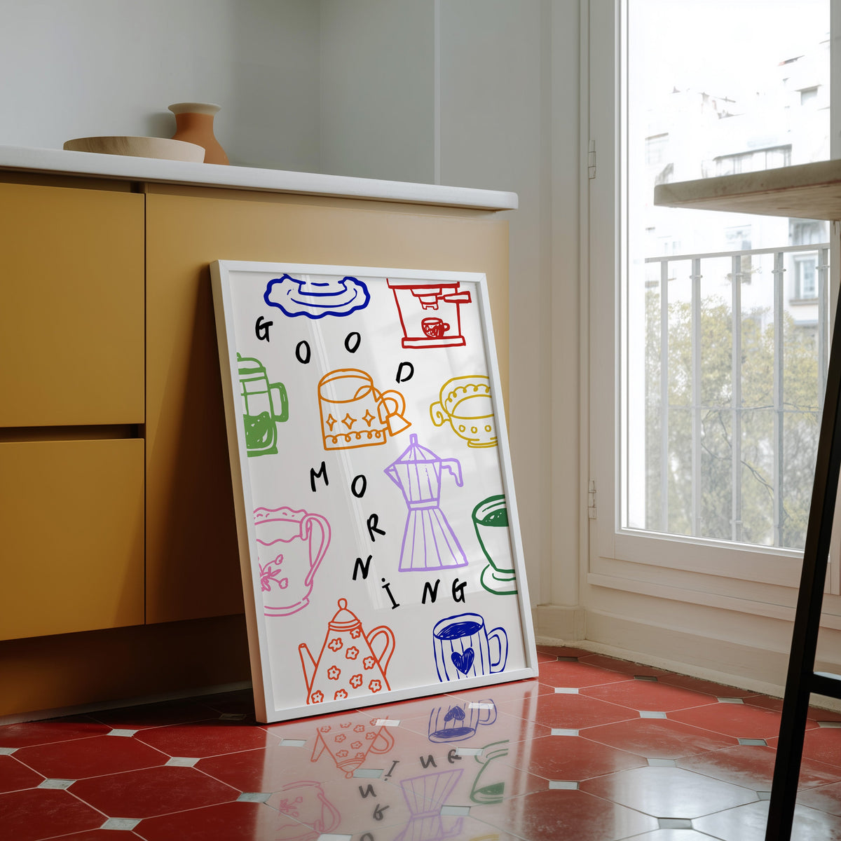 Good Morning coffee print in a white frame against yellow cabinets on a red tiled floor