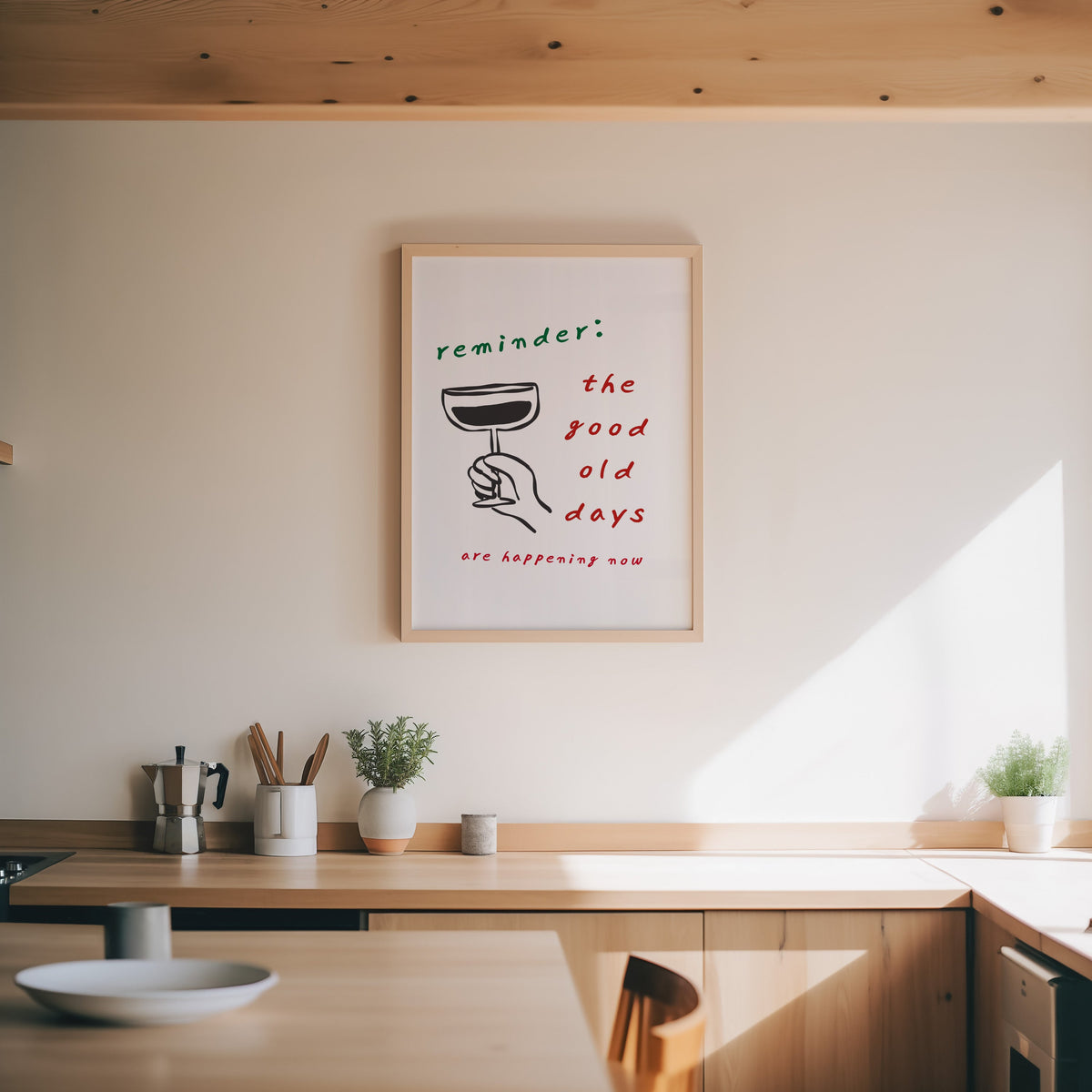 Good Old Days print in an oak frame above a wood counter with a moka pot and herbs