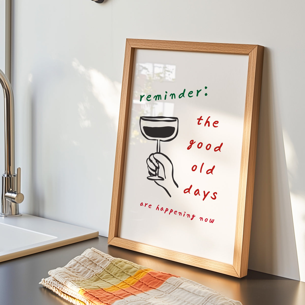 Good Old Days print in an oak frame by the kitchen sink beside a striped tea towel