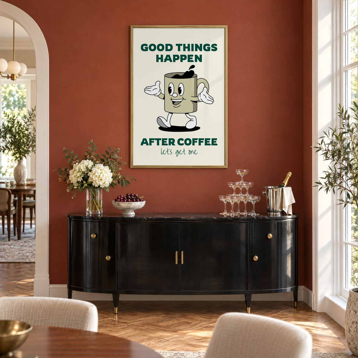 Good Things Happen After Coffee mug print in a brass frame on a terracotta wall above a black buffet with a champagne tower