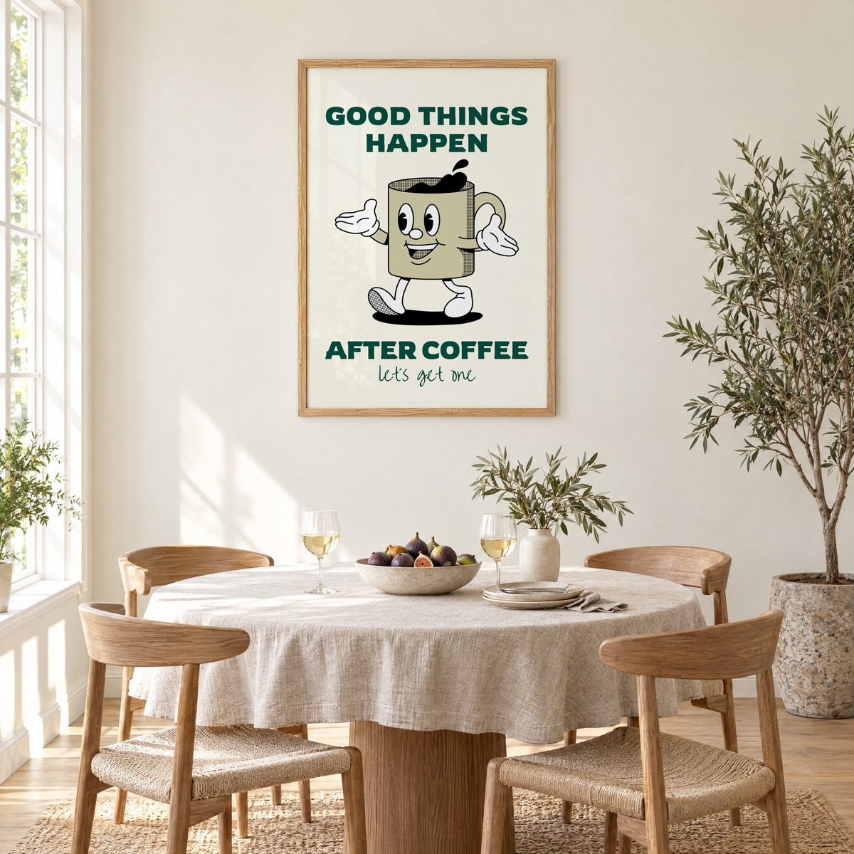 Good Things Happen After Coffee mug print in an oak frame above a round linen-covered dining table with figs and wine