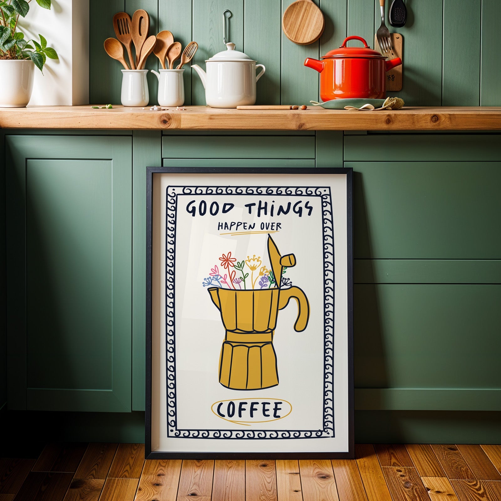Good things happen over coffee print in a black frame against sage green kitchen cabinets