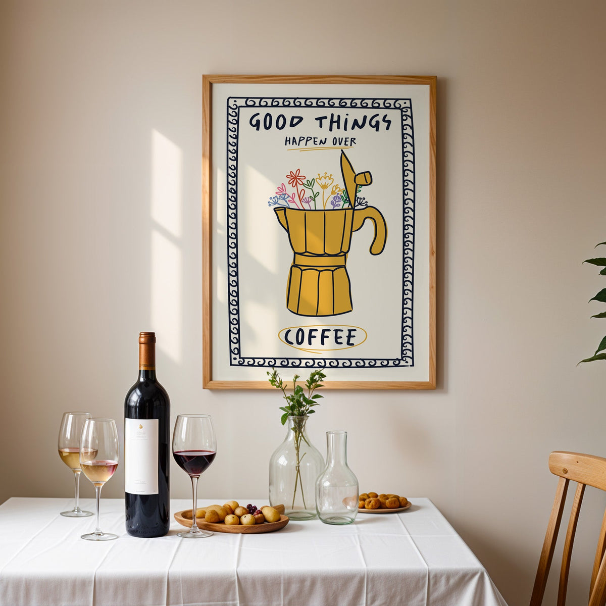 Good things happen over coffee print in an oak frame above a table laid with red wine
