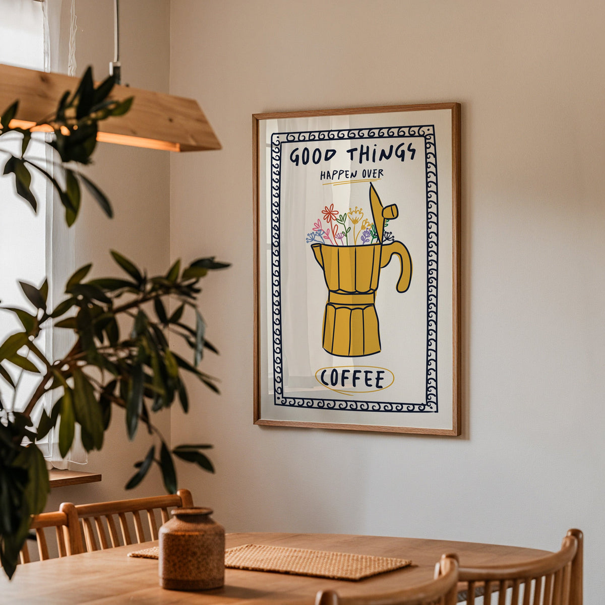 Good things happen over coffee print in a walnut frame above a table beside an olive tree