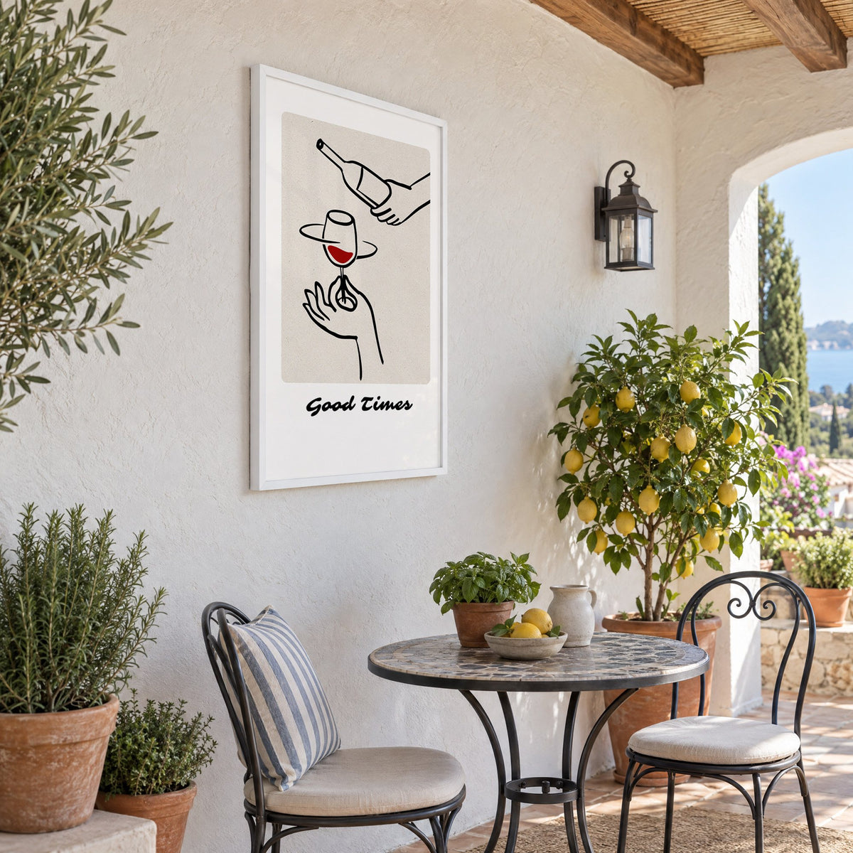 Good Times wine pour line art print in a white frame on a sunny patio wall beside a potted lemon tree