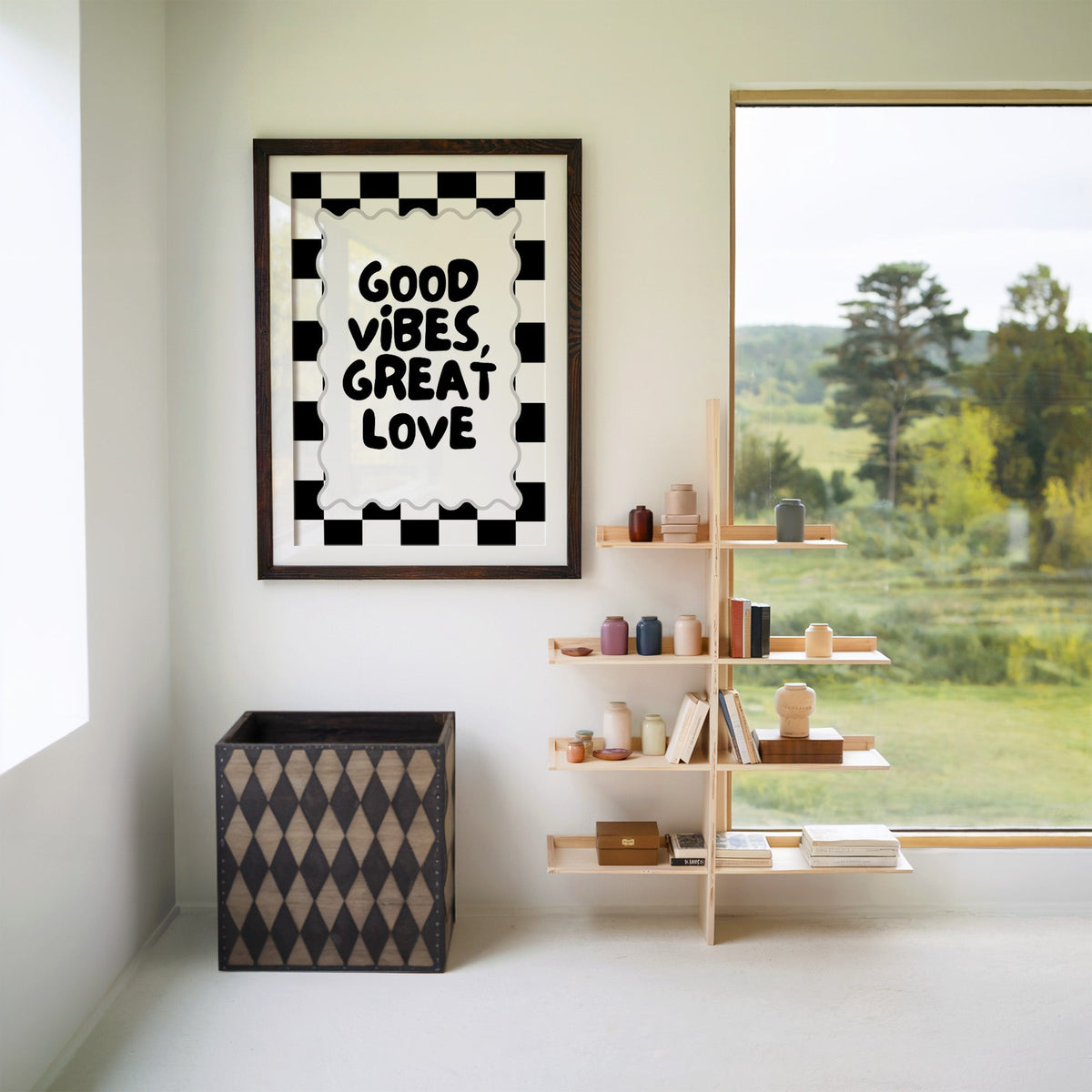 Good vibes great love checkerboard quote print in a walnut frame with a white mat beside wooden shelves and a garden window