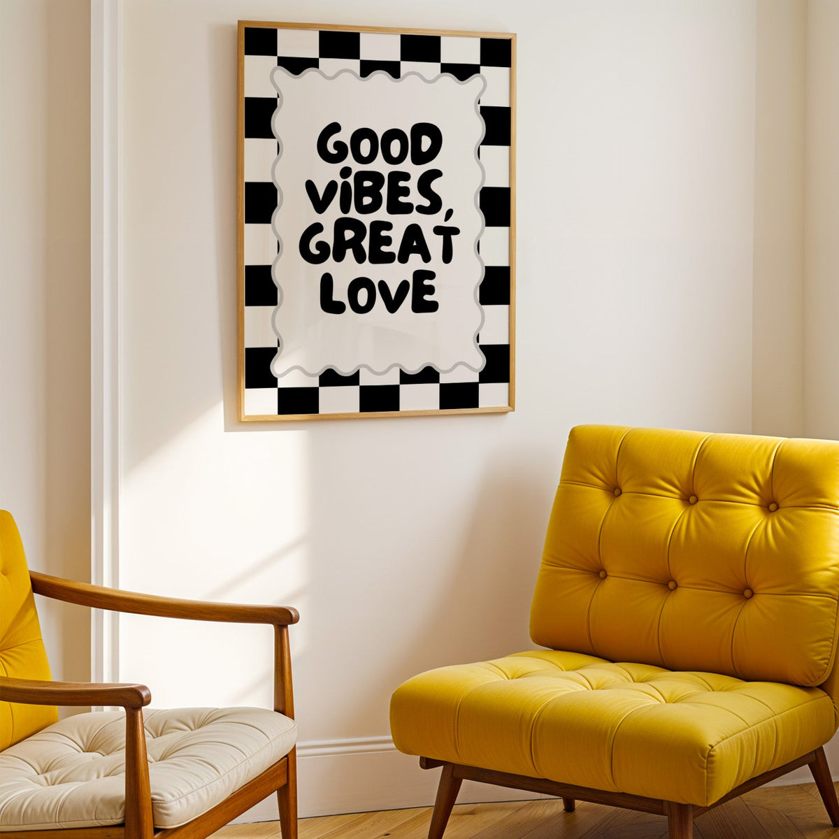 Good vibes great love checkerboard quote print shown in a gold frame above a mustard yellow tufted armchair
