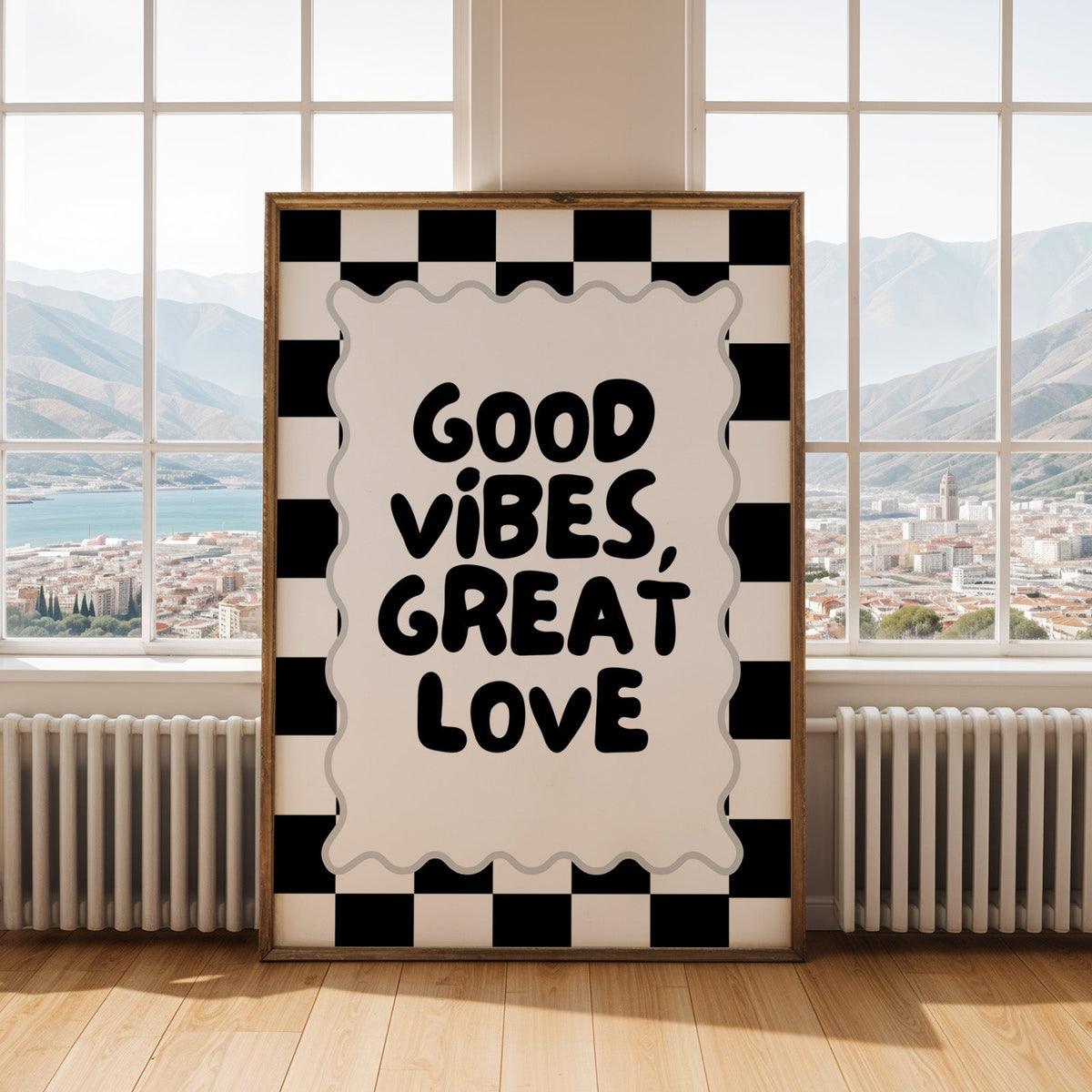 Good vibes great love checkerboard quote print shown in an antique gold frame by tall windows with a sea view