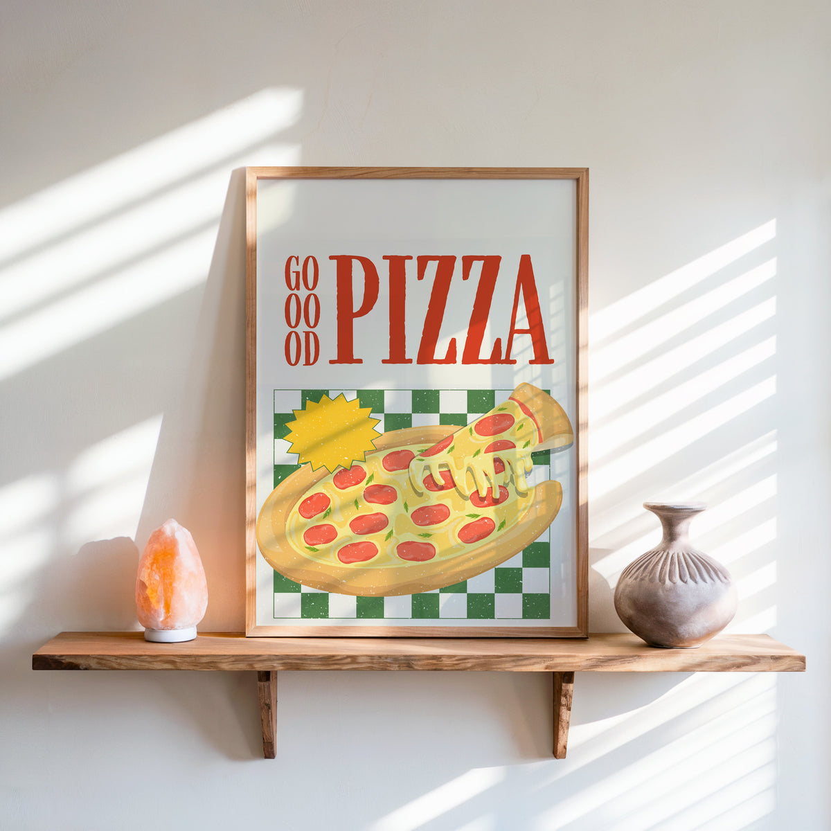 Goood Pizza print in an oak frame on a live-edge shelf beside a salt lamp