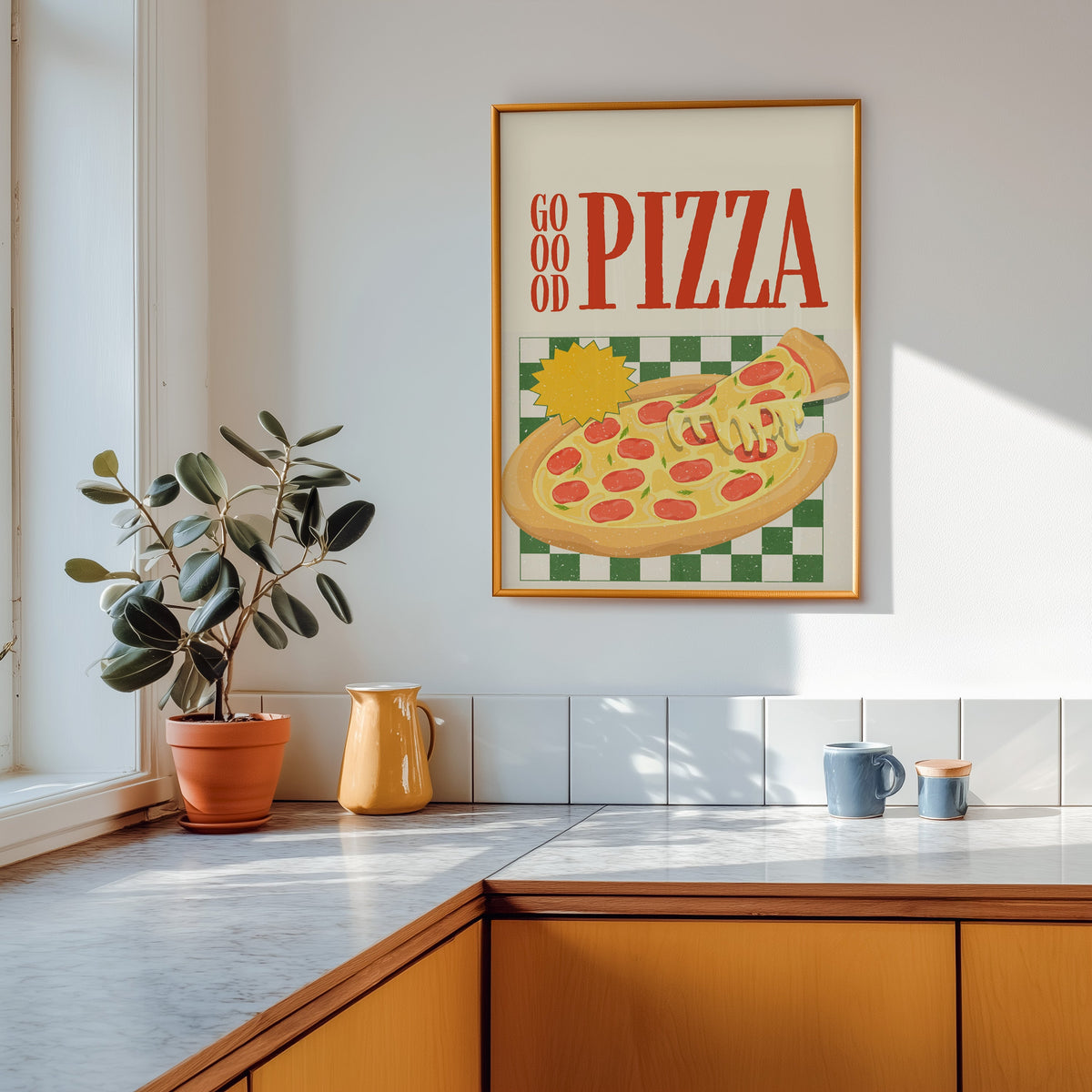 Goood Pizza print shown in a gold frame above a marble counter in a tan kitchen