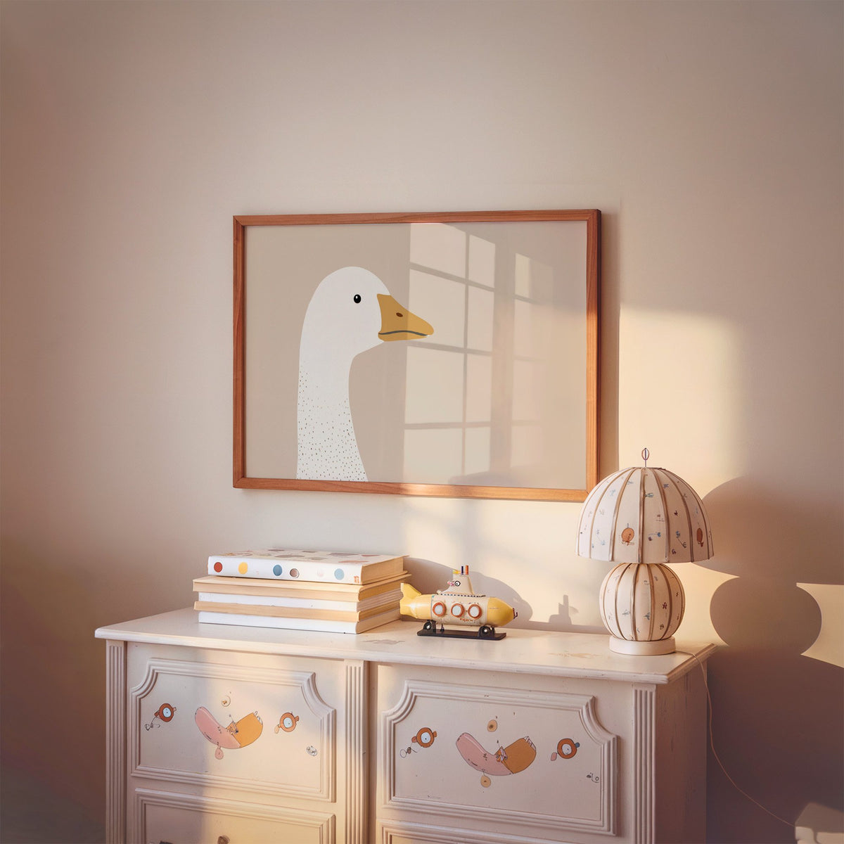 Landscape goose head profile nursery print in a cherry wood frame above a painted dresser and lamp