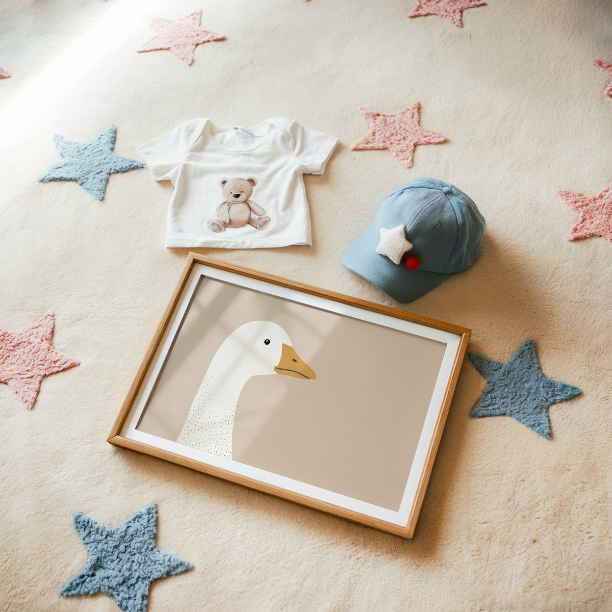 Landscape goose head profile nursery print in a matted oak frame on a star rug with a baby tee