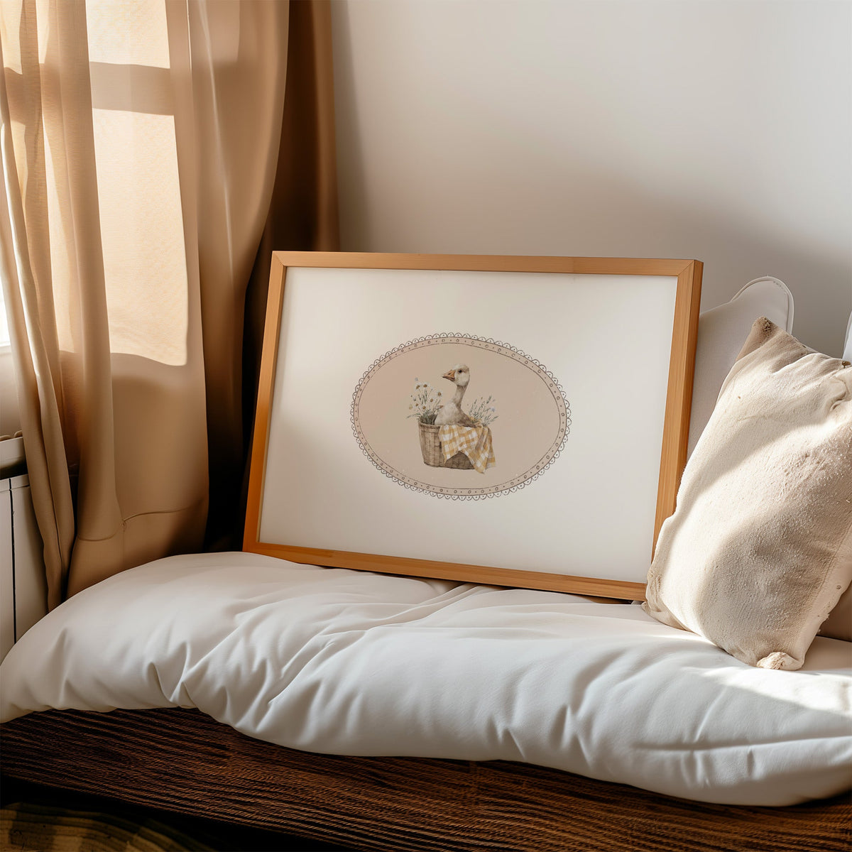 Goose in wicker basket with gingham in lace oval nursery print in a honey wood frame on a cushioned window seat by sheer curtains