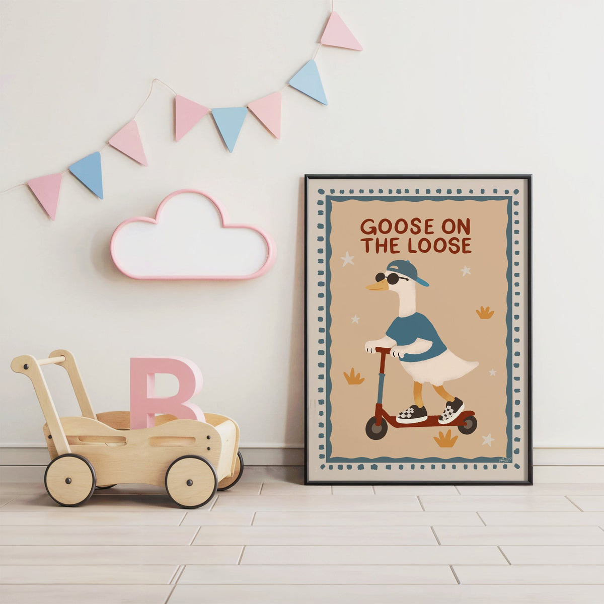 Goose on the loose scooter nursery print in a black frame under pastel bunting by a wooden baby walker