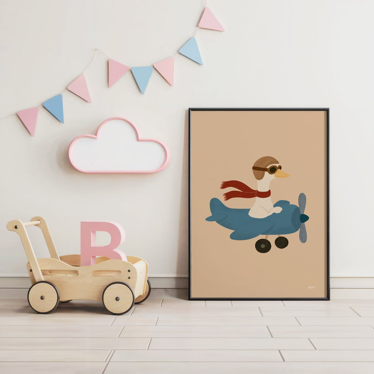 Goose pilot in blue airplane nursery print in a black frame under pastel bunting by a wooden baby walker