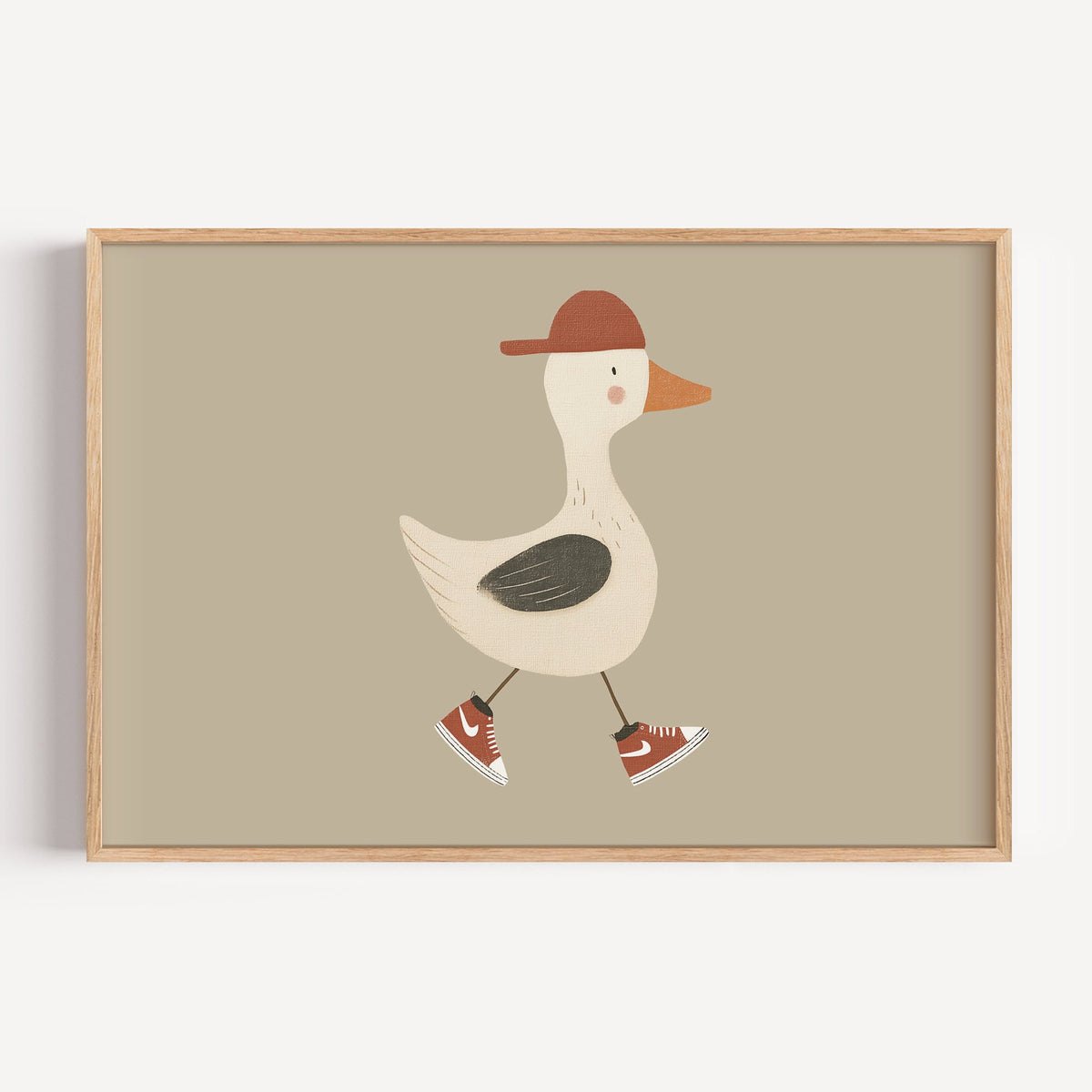 Landscape goose red cap and sneakers nursery print in a light oak frame on a plain white wall