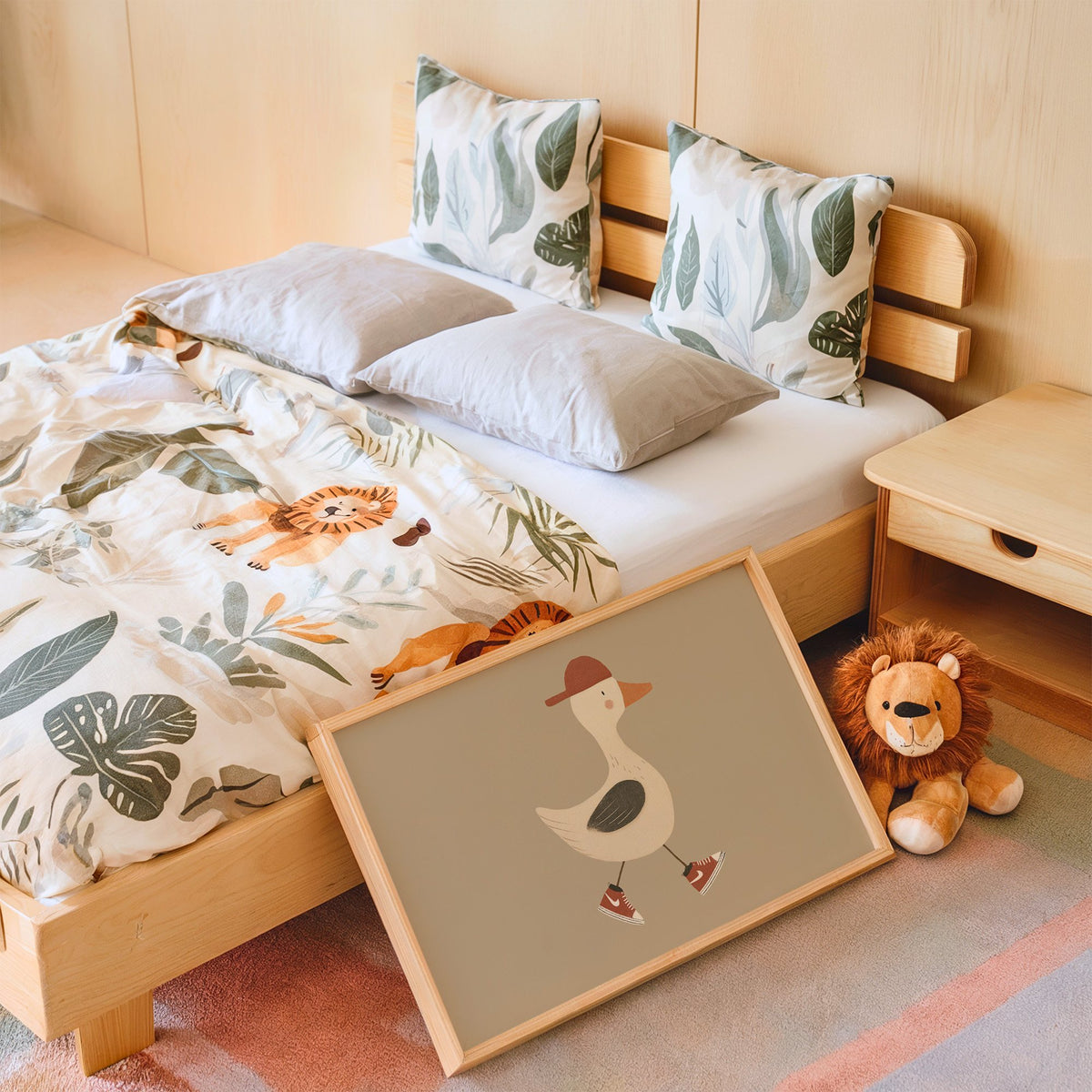 Landscape goose red cap and sneakers nursery print in an oak frame leaning on a kids bed by a lion plush