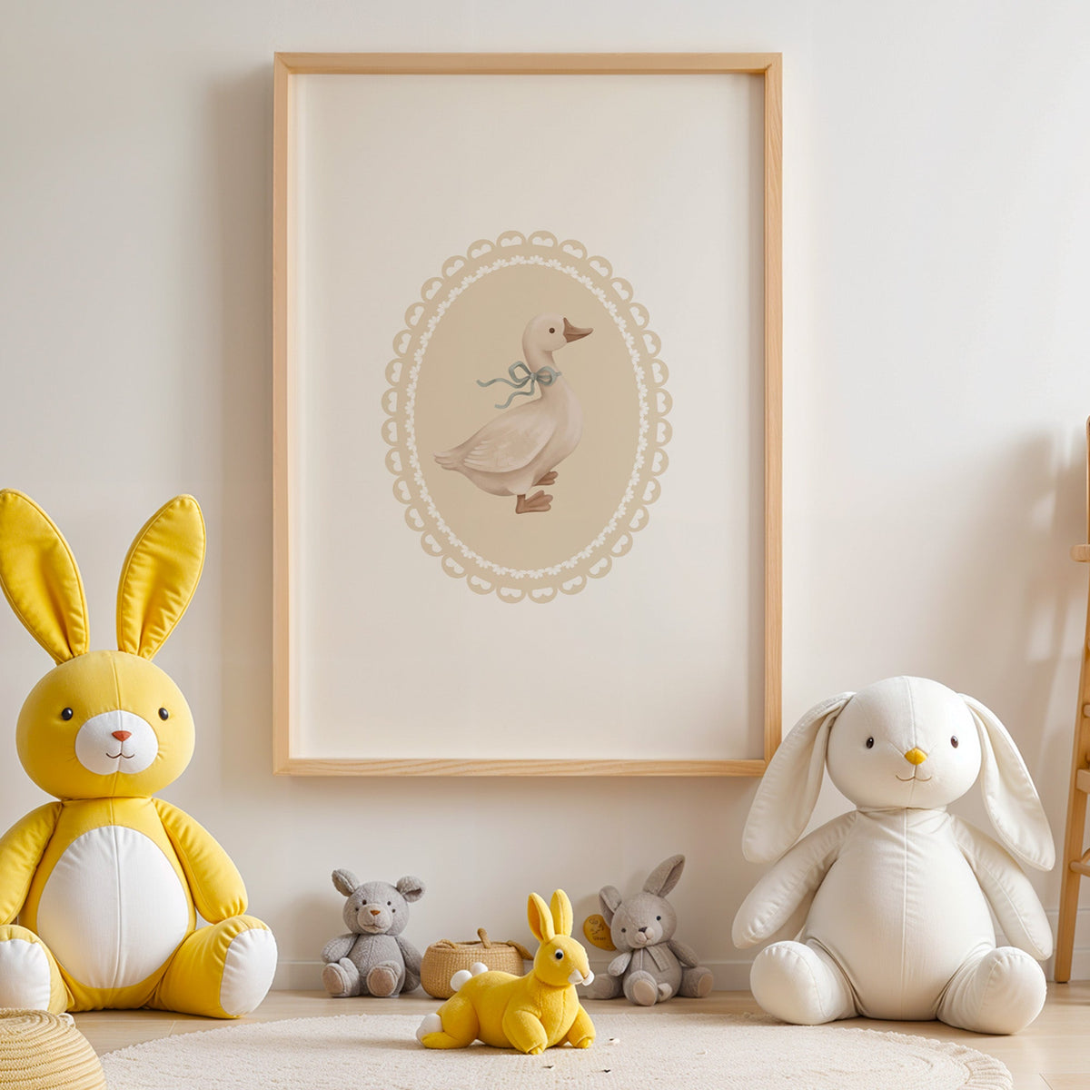 Goose with sage ribbon in heart lace oval nursery print in an oak frame above yellow and white plush bunnies