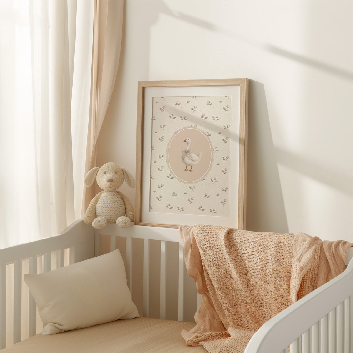 White goose with striped bow in lace oval nursery print shown in an oak frame with a white mat on a crib rail