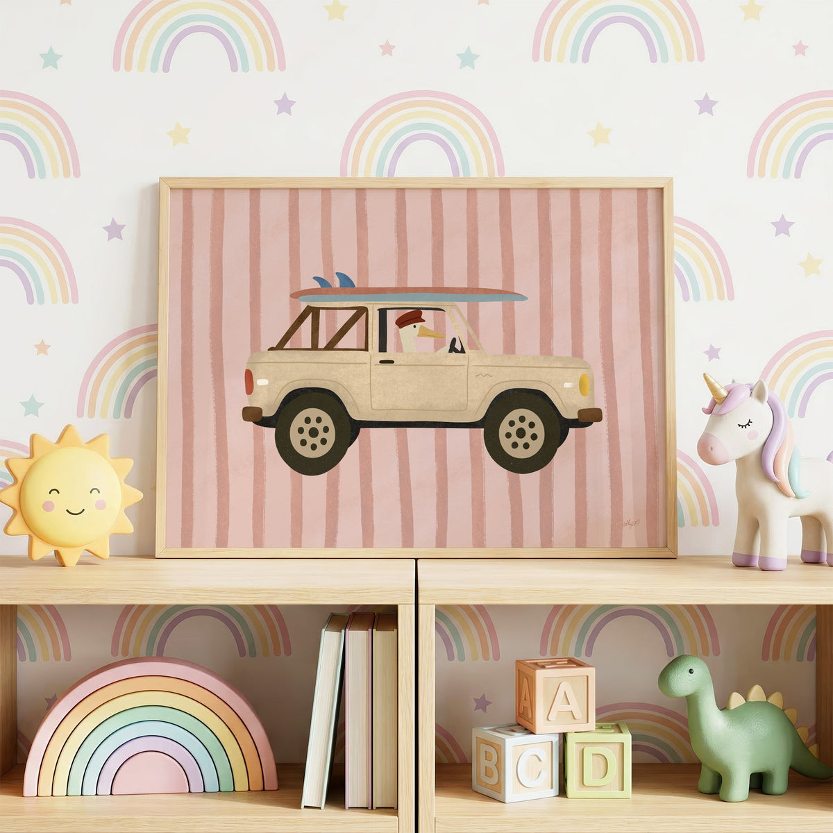 Goose driving cream surf truck nursery print in an oak frame on a toy shelf against rainbow wallpaper