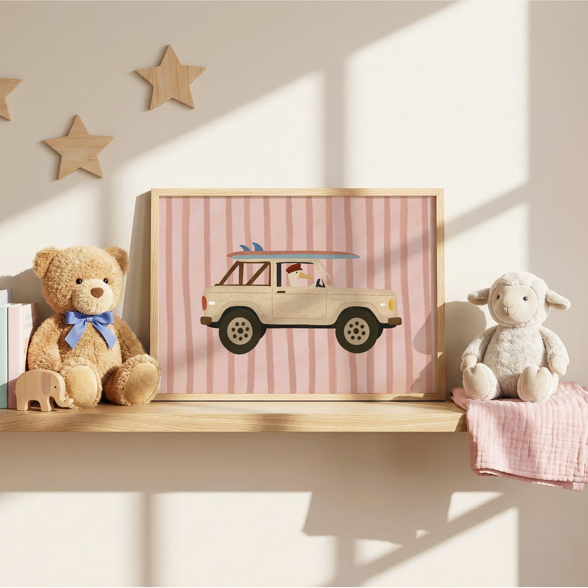 Goose driving cream surf truck nursery print in an oak frame on a wall shelf between a teddy bear and a toy lamb