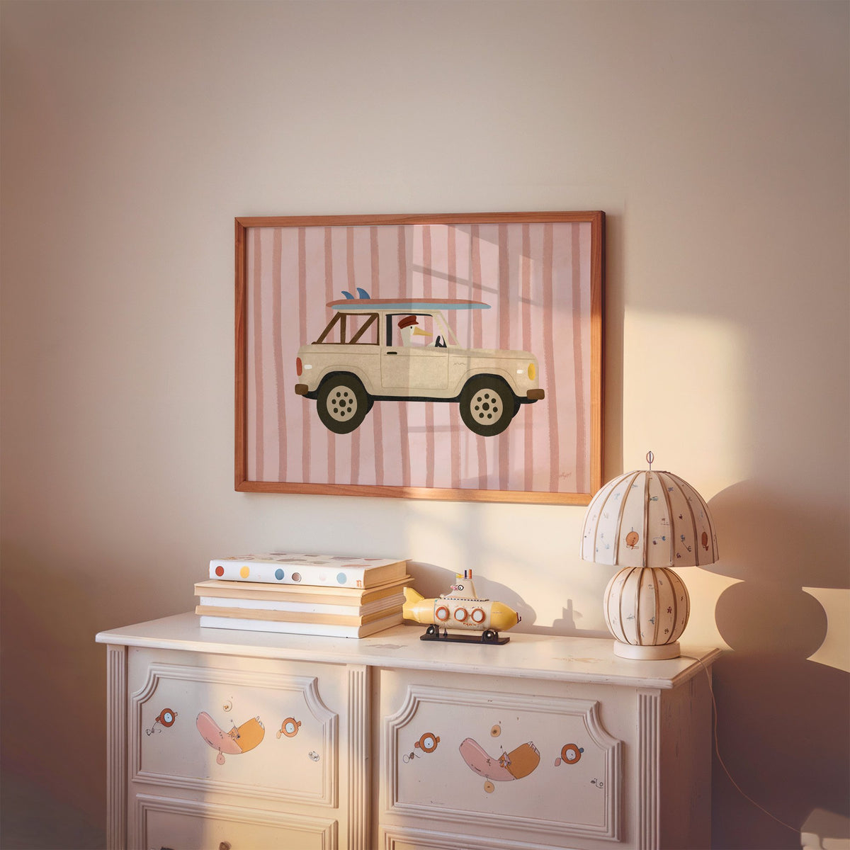 Goose driving cream surf truck nursery print in a cherry wood frame above a painted dresser and lamp