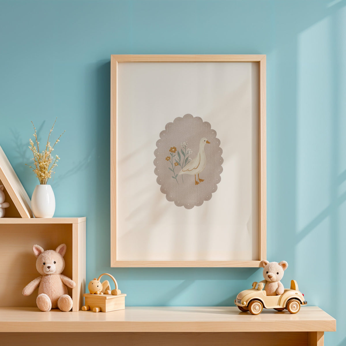 White goose and wildflowers in scalloped oval nursery print in an oak frame on a blue wall above a shelf of wooden toys