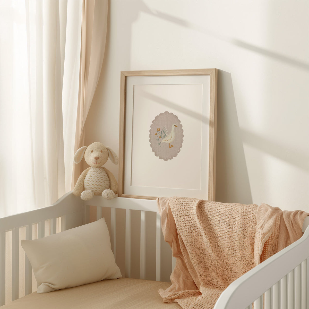 White goose and wildflowers in scalloped oval nursery print shown in an oak frame with a white mat on a crib rail