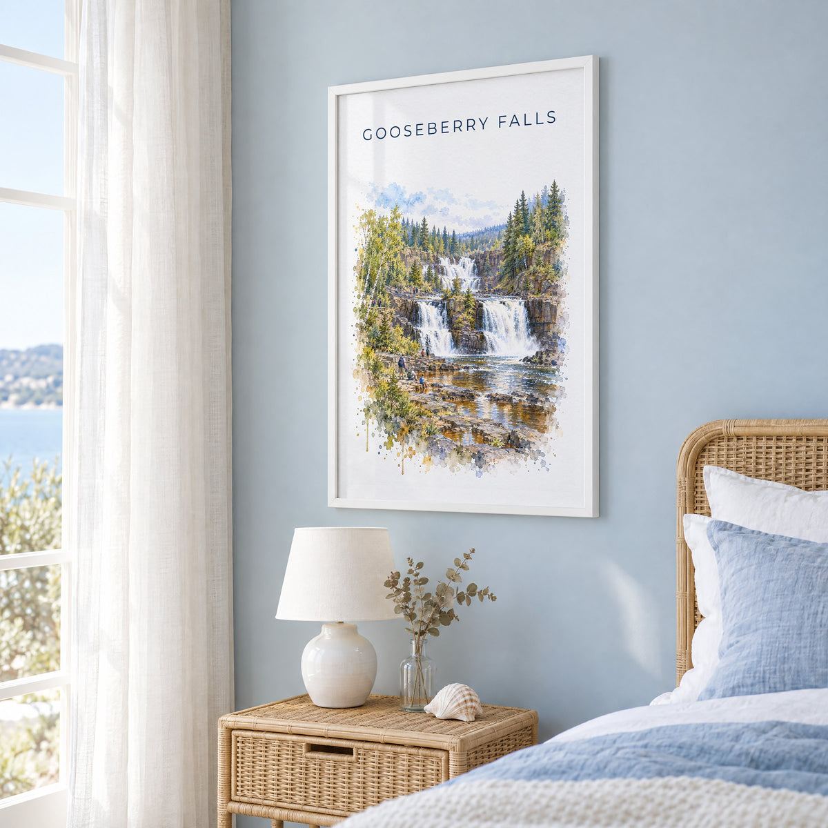 Gooseberry Falls State Park watercolor print in a white frame on a pale blue wall beside a rattan bed in a coastal bedroom