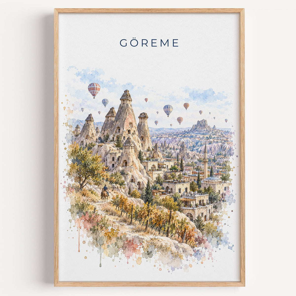 Göreme watercolor print in a light oak frame on a plain white wall