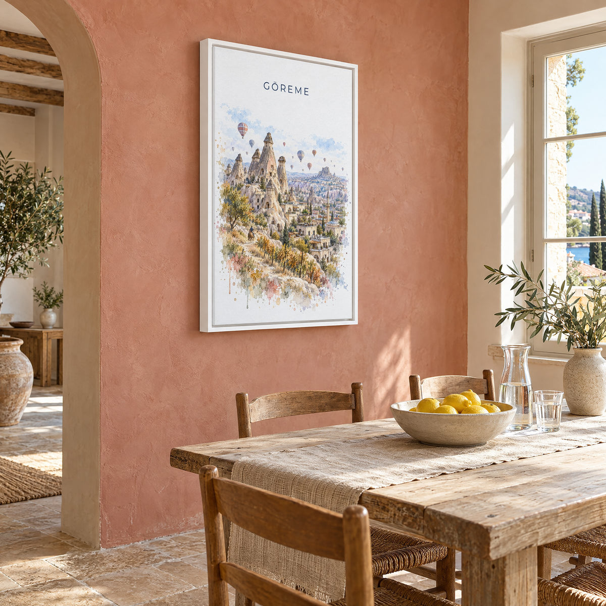 Göreme watercolor print as a white floater canvas on a terracotta wall above a rustic dining table