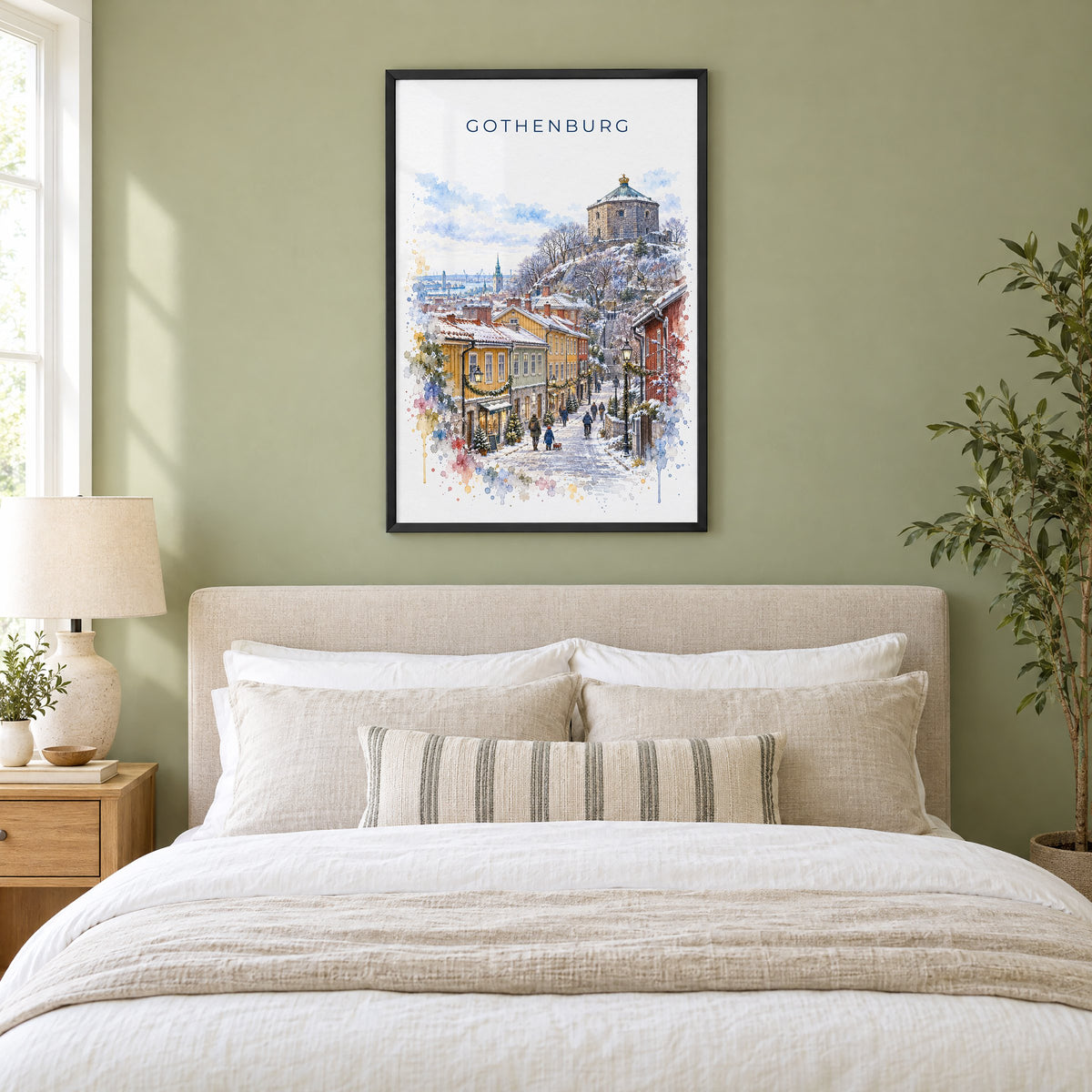 Gothenburg watercolor print in a black frame above an upholstered headboard in a sage green bedroom