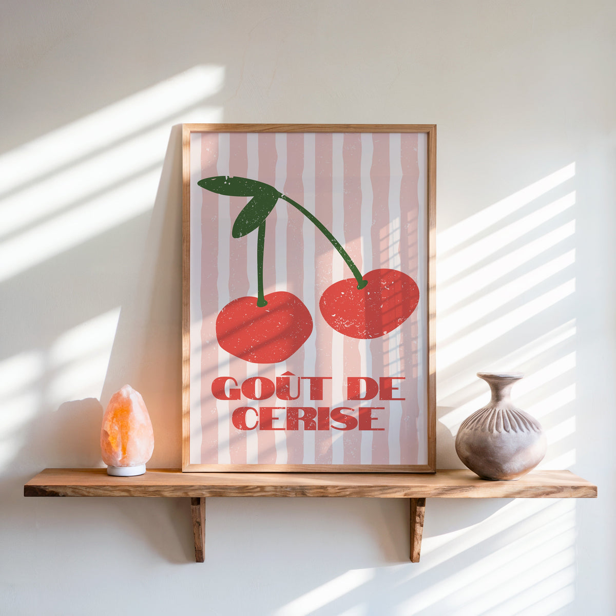 Gout de Cerise cherry print in an oak frame on a live-edge shelf beside a salt lamp