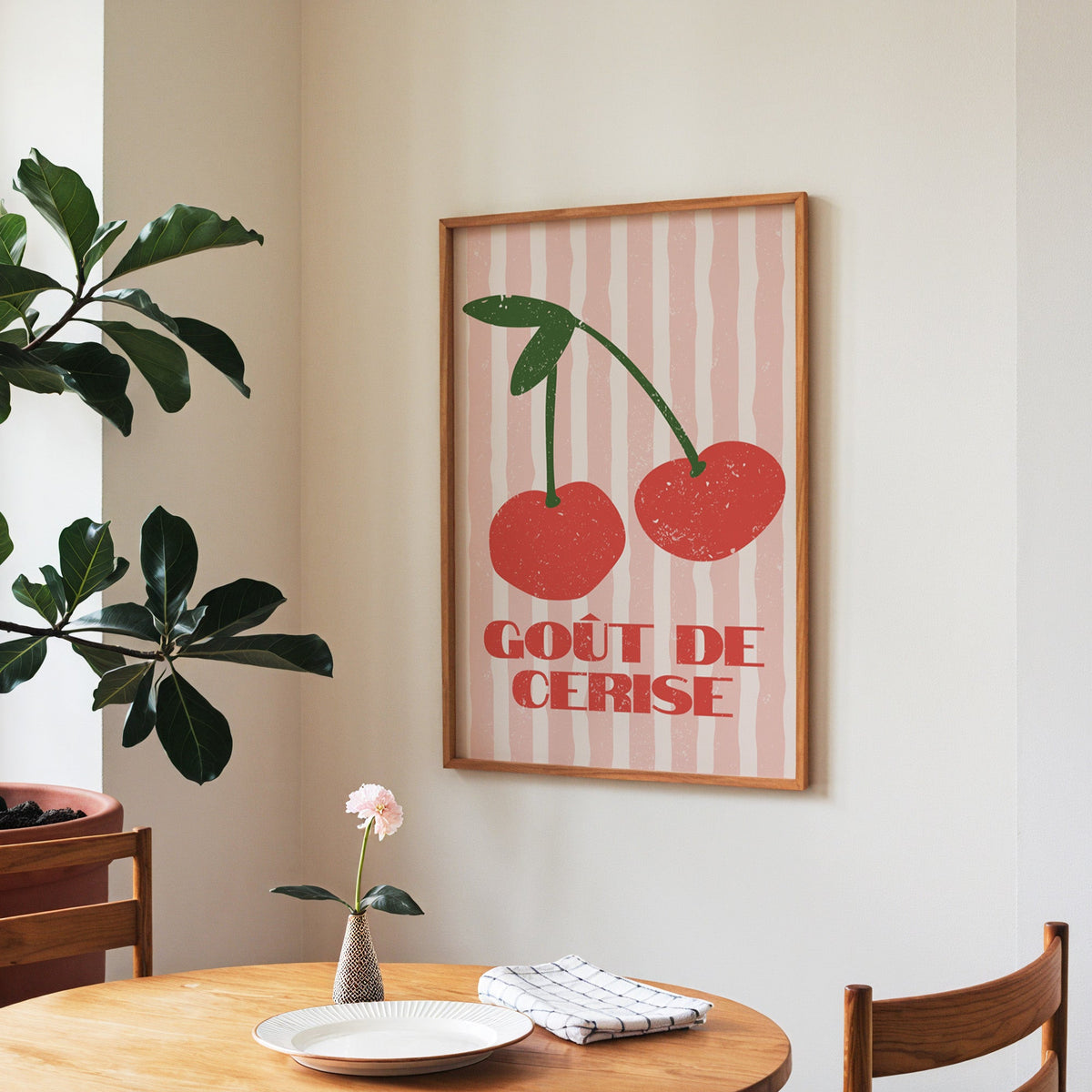 Gout de Cerise cherry print in a walnut frame above a round table beside a fiddle-leaf fig