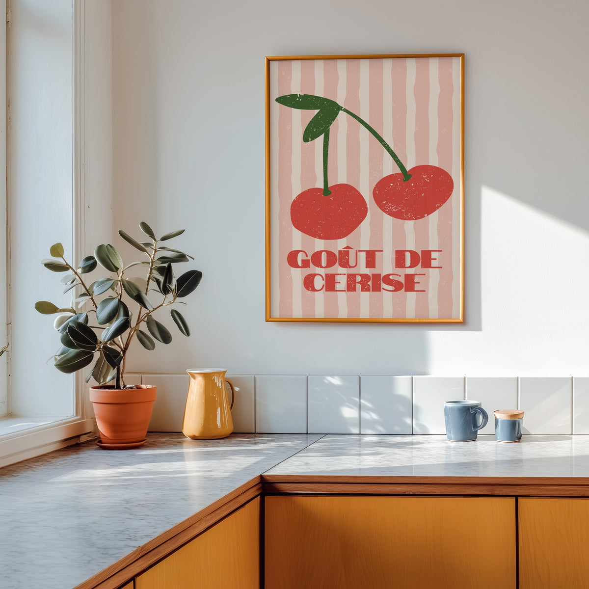Gout de Cerise cherry print shown in a gold frame above a marble counter in a tan kitchen