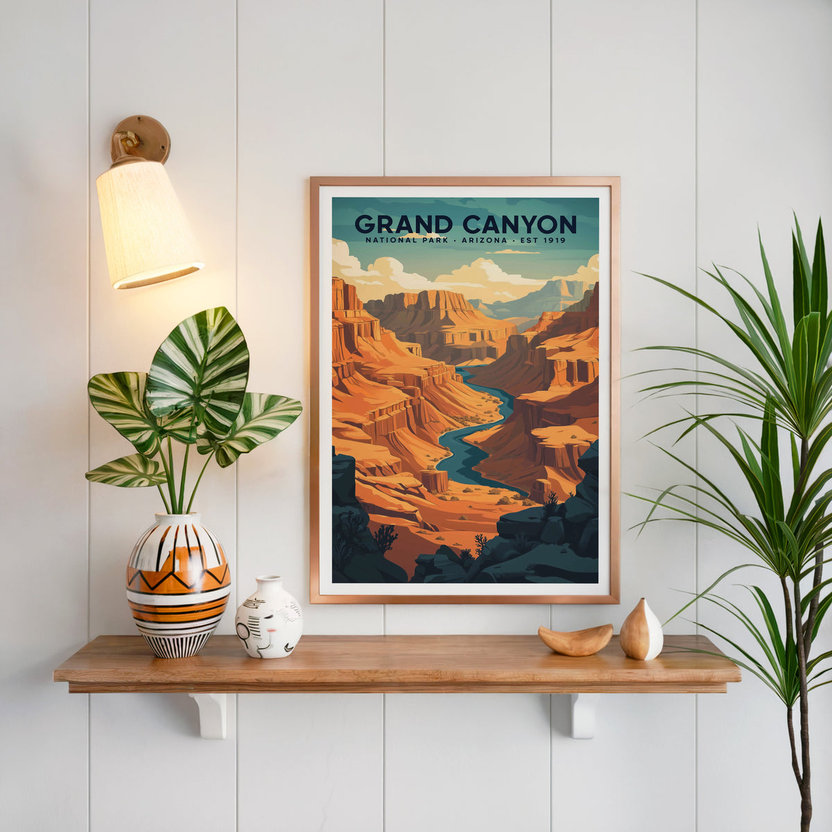 Grand Canyon National Park print in a copper frame above an oak shelf on white shiplap with a sconce