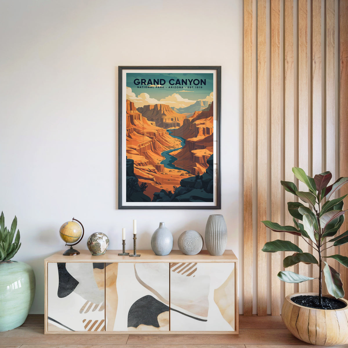 Grand Canyon National Park print in a black frame above a light wood sideboard with a globe and vases