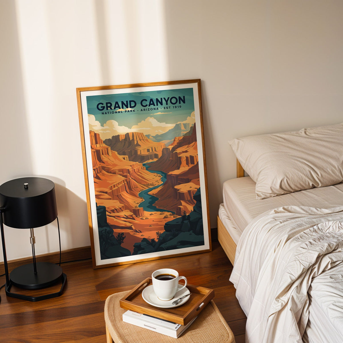 Grand Canyon National Park print in an oak frame leaning on a bedroom floor beside the bed and a tray