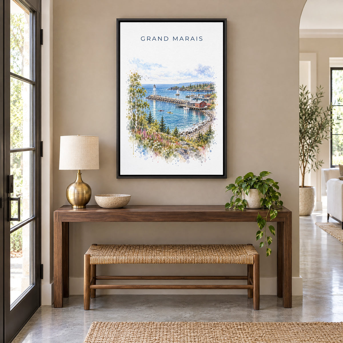 Grand Marais, Minnesota watercolor print as a black floater canvas above a walnut console and woven bench in an entryway