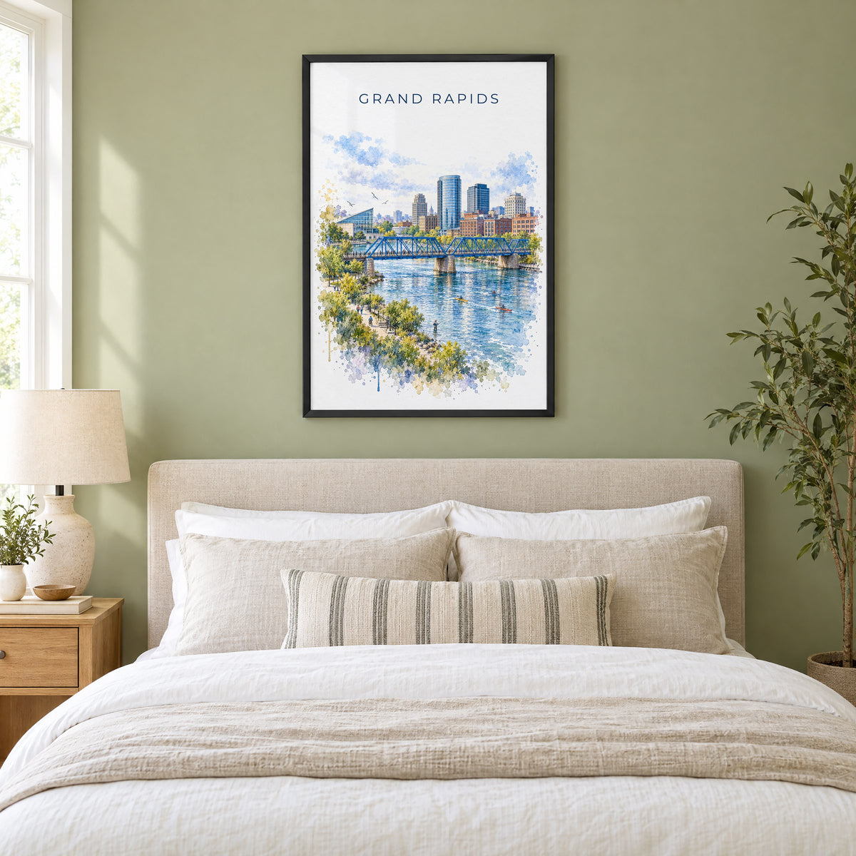 Grand Rapids watercolor print in a black frame above an upholstered headboard in a sage green bedroom
