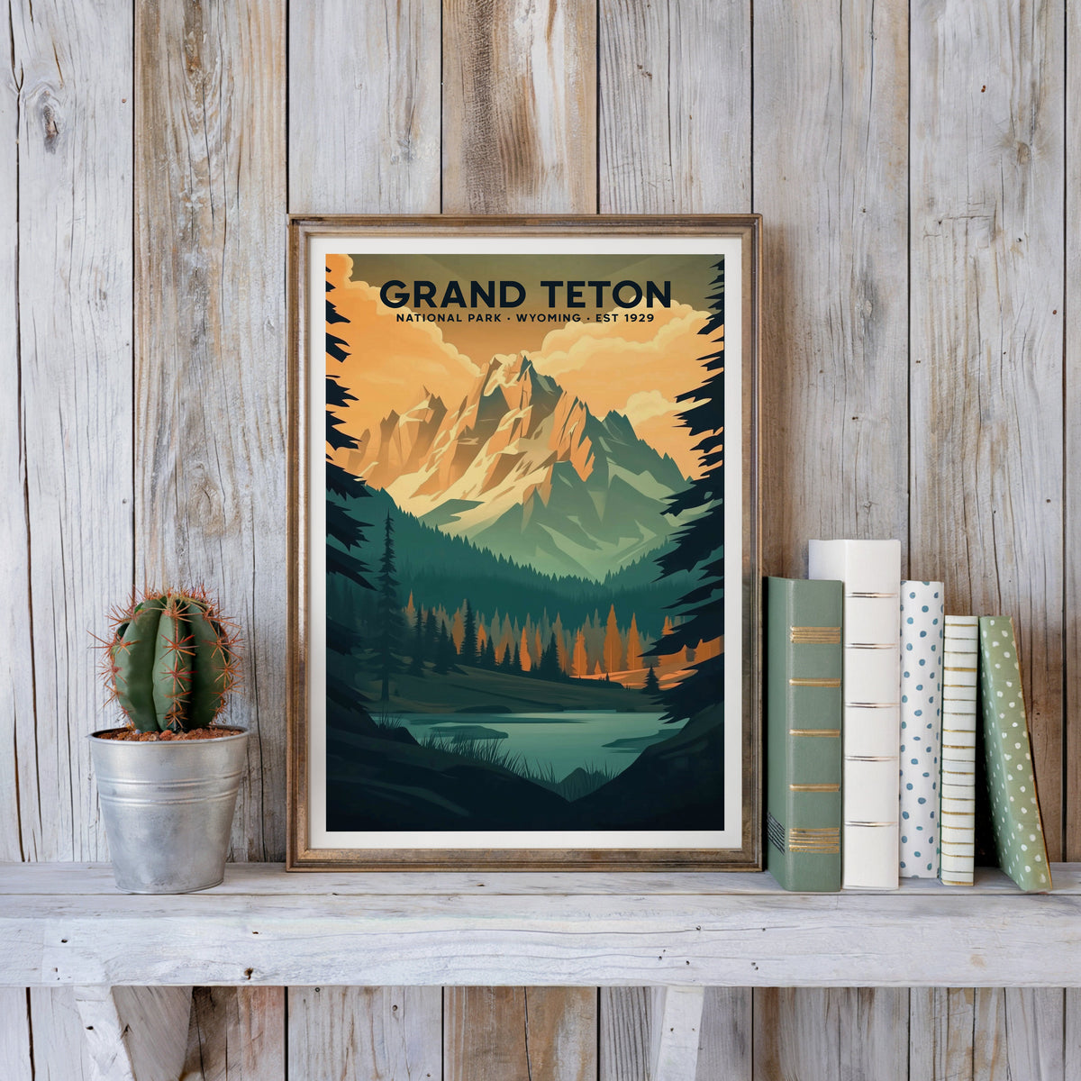 Grand Teton poster in an antique gold frame against whitewashed farmhouse planks beside books and a cactus