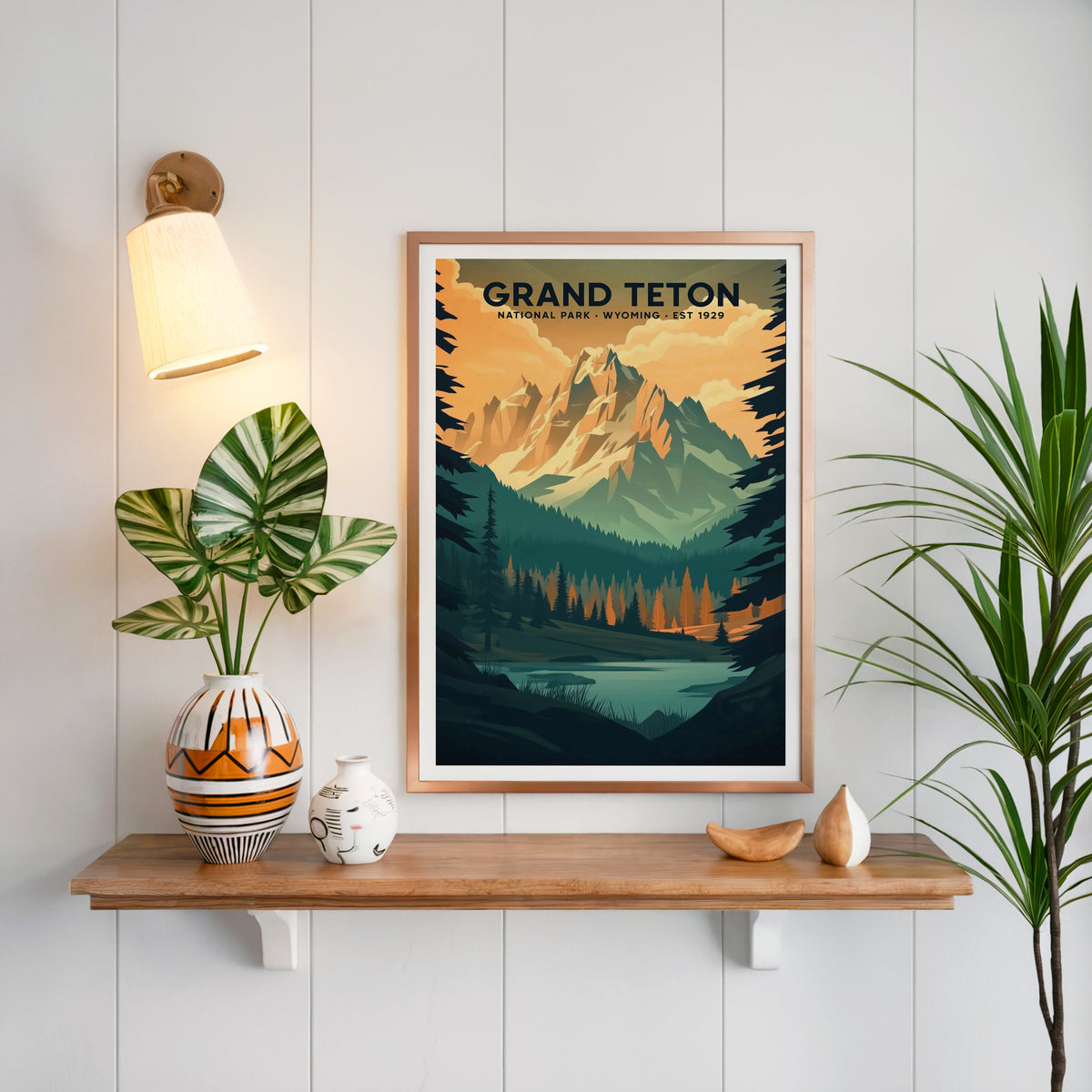 Grand Teton National Park print in a copper frame above an oak shelf on white shiplap with a sconce