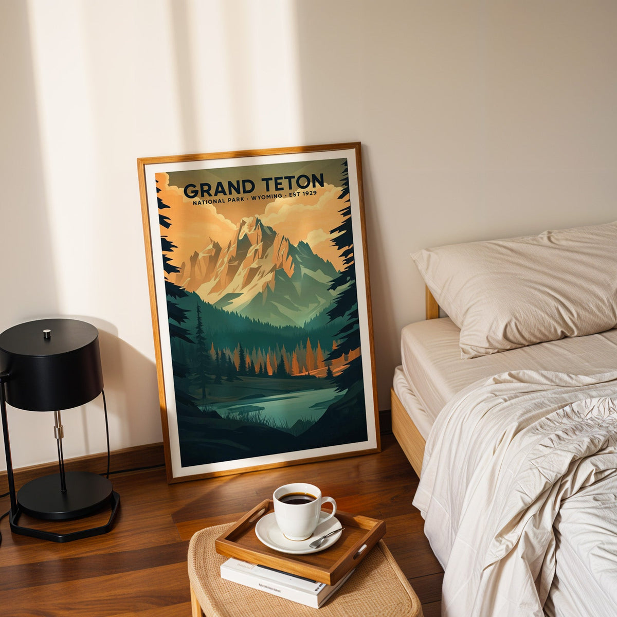 Grand Teton National Park print in an oak frame leaning on a bedroom floor beside the bed and a tray