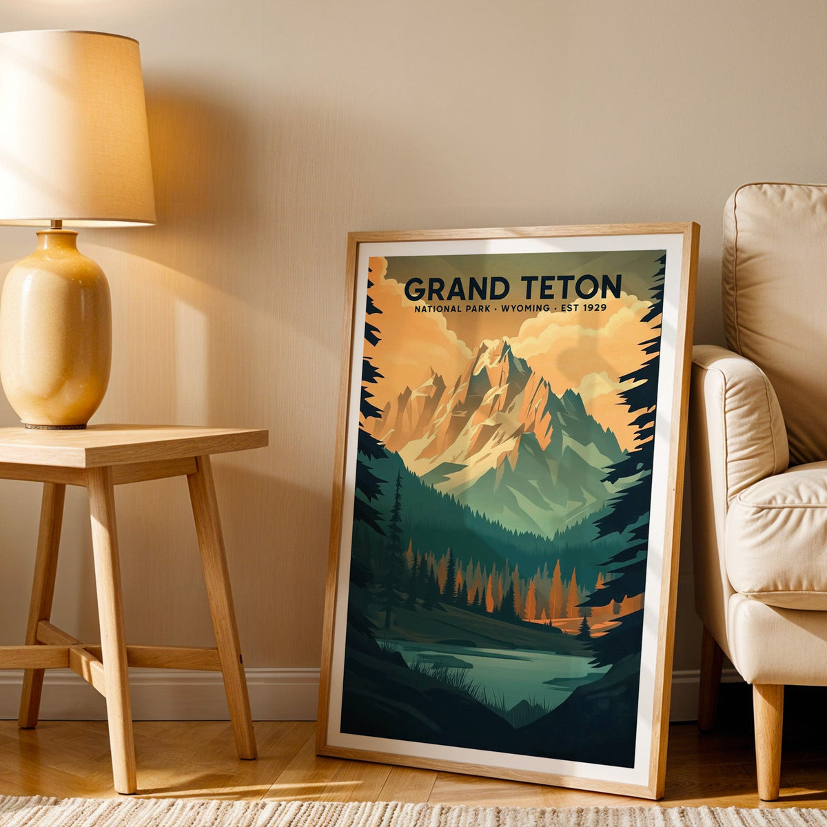 Grand Teton print in an oak frame beside a cream armchair and an amber lamp in warm afternoon light