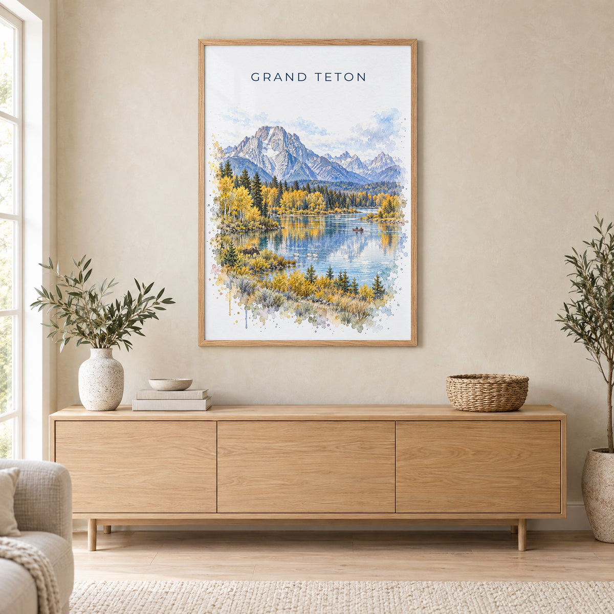 Grand Teton National Park watercolor print in an oak frame above a light wood sideboard in a Scandinavian living room