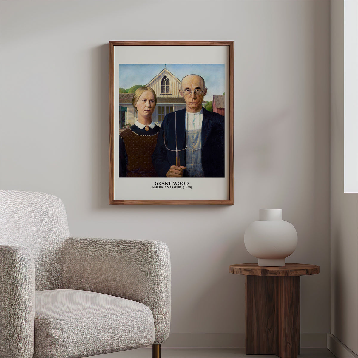 American Gothic print in a slim walnut frame above a bouclé armchair