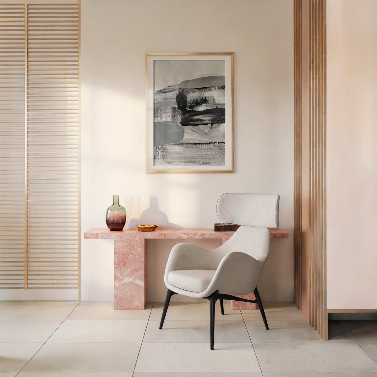 Gray and black dry brush layers abstract print shown in a gold frame with a mat above a pink marble console and armchair