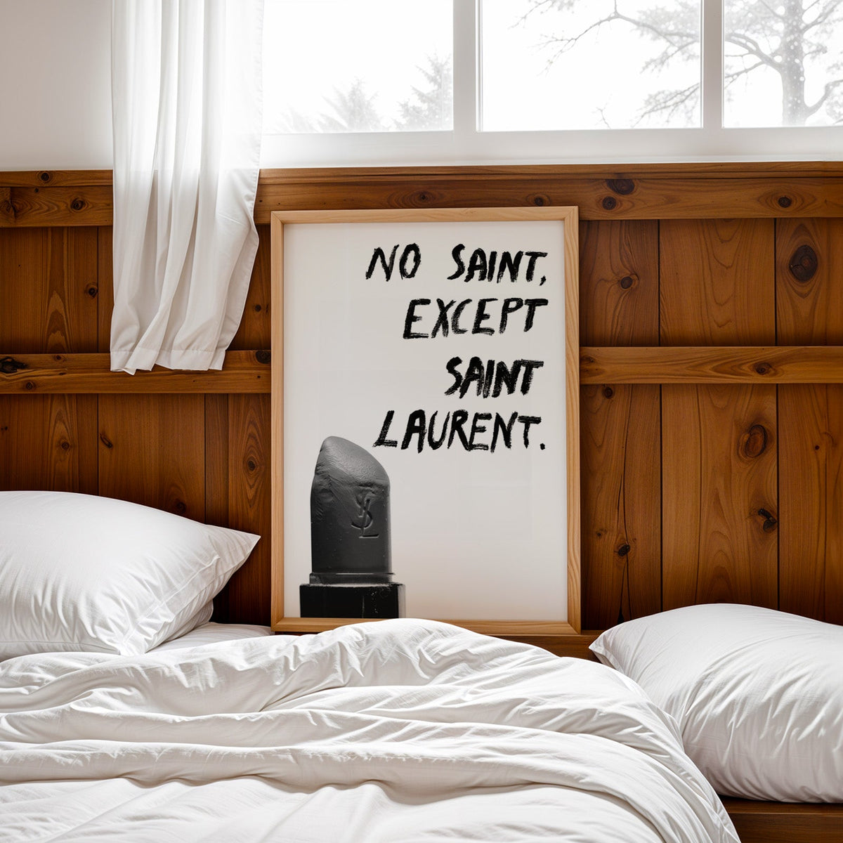 Gray lipstick with black brush lettering quote print in a pine frame leaning on a wood headboard over white bedding
