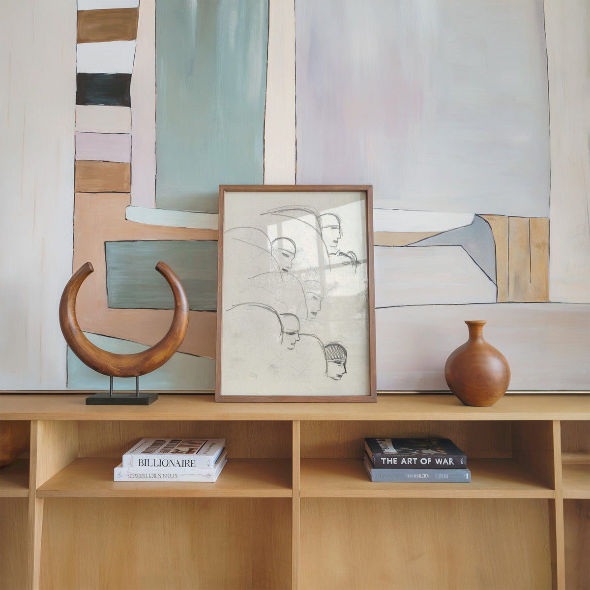 Gray pencil bob hair profiles figure sketch print in a walnut frame on an oak shelf beside a wooden crescent sculpture