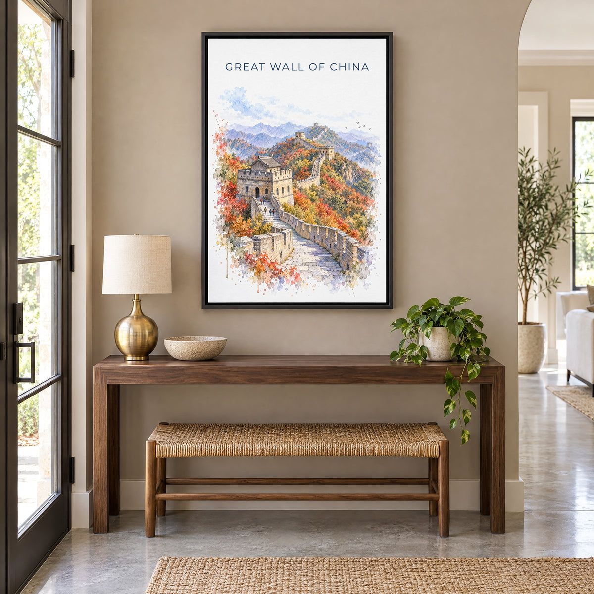 Great Wall of China watercolor print as a black floater canvas above a walnut console and woven bench in an entryway
